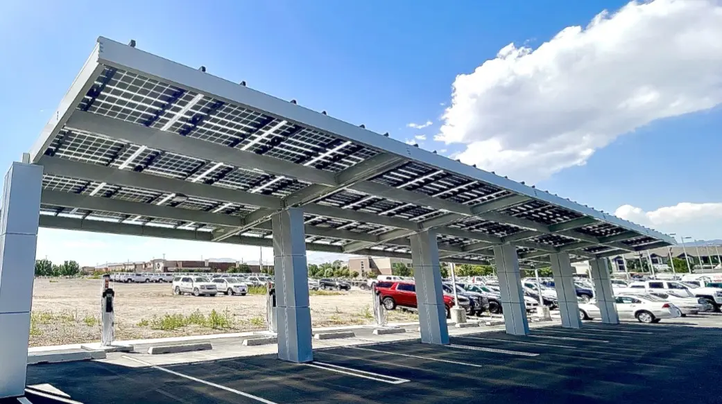 Solar carport canopy structure in a commercial parking lot under a blue sky