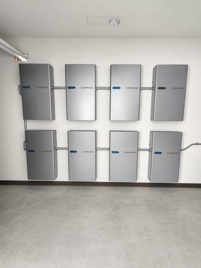 Eight wall-mounted solar battery storage units installed in a residential garage