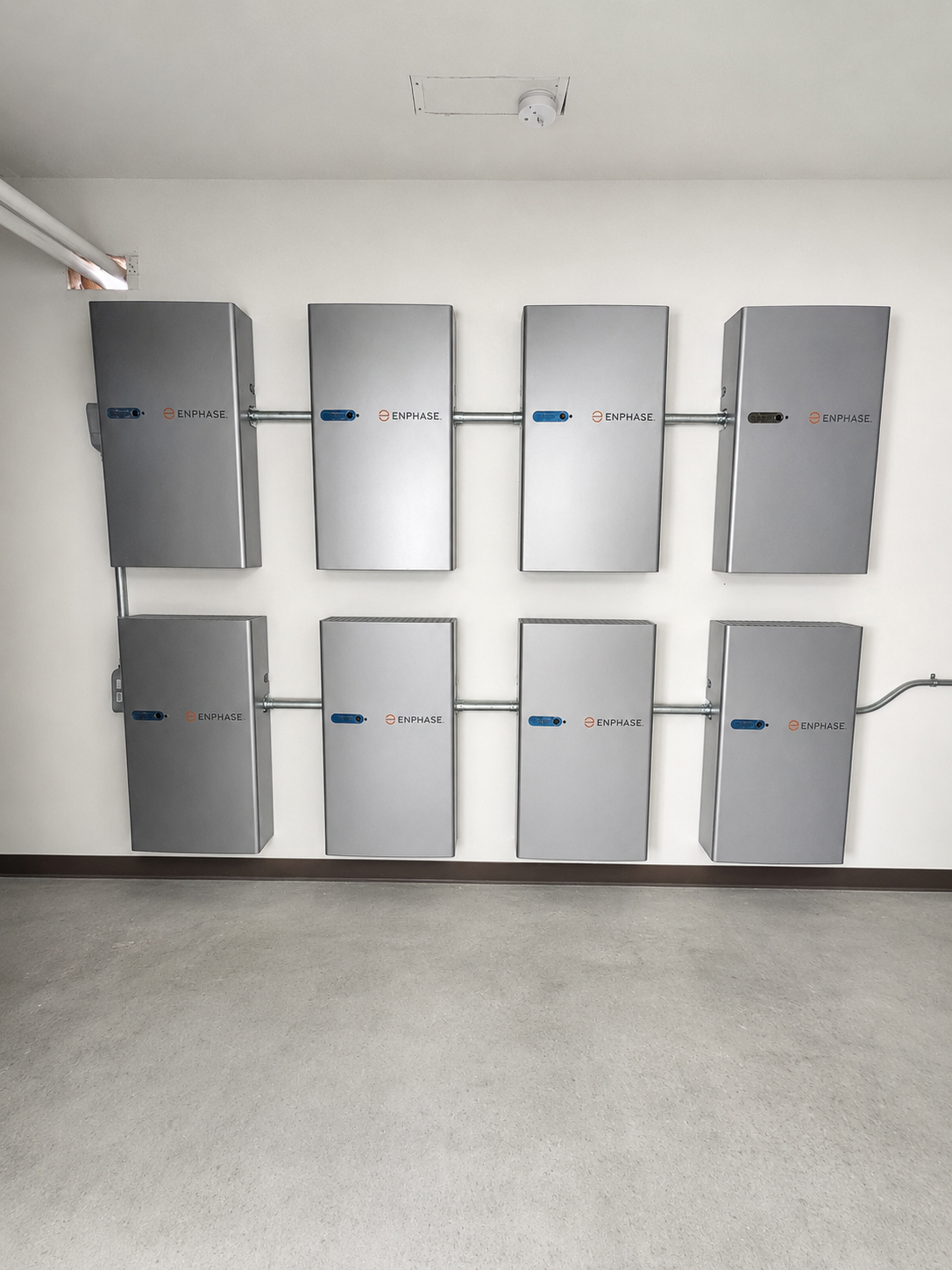 Eight wall-mounted solar battery storage units installed in a residential garage
